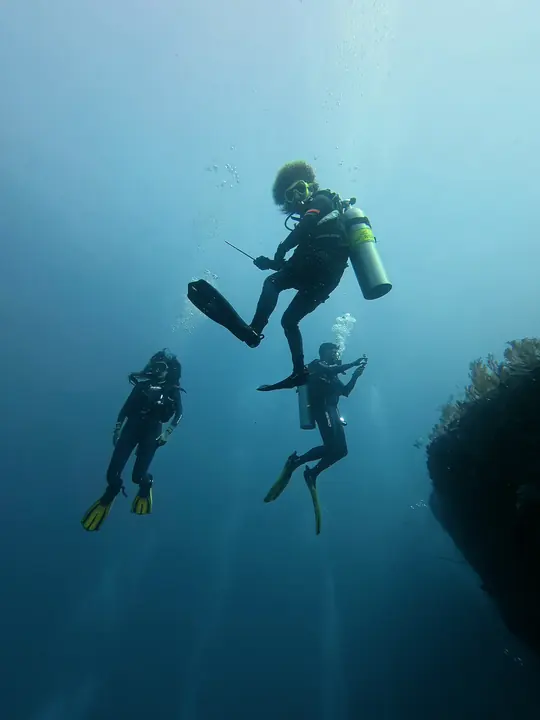 Divers descending along the wall